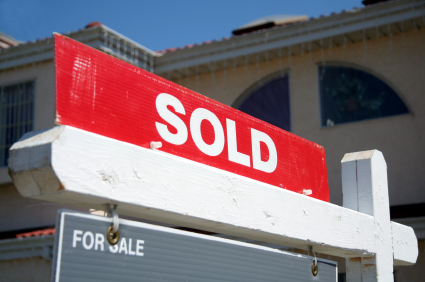 "Sold" sign in front of a house as real estate demand remains high